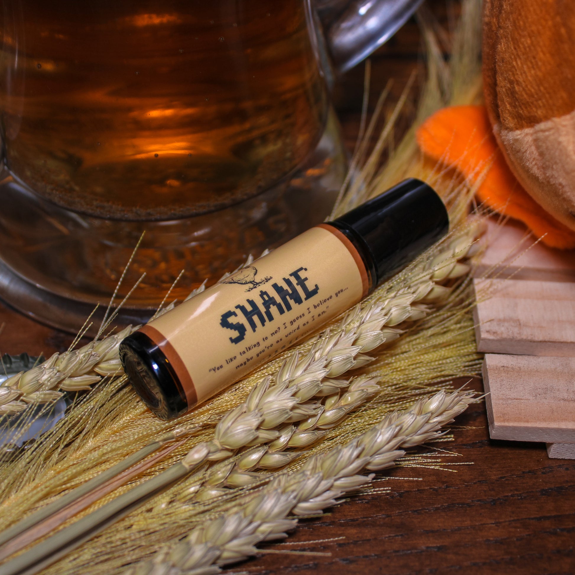 Shane product roller bottle on a wooden surface with a mug and wheat stalks.